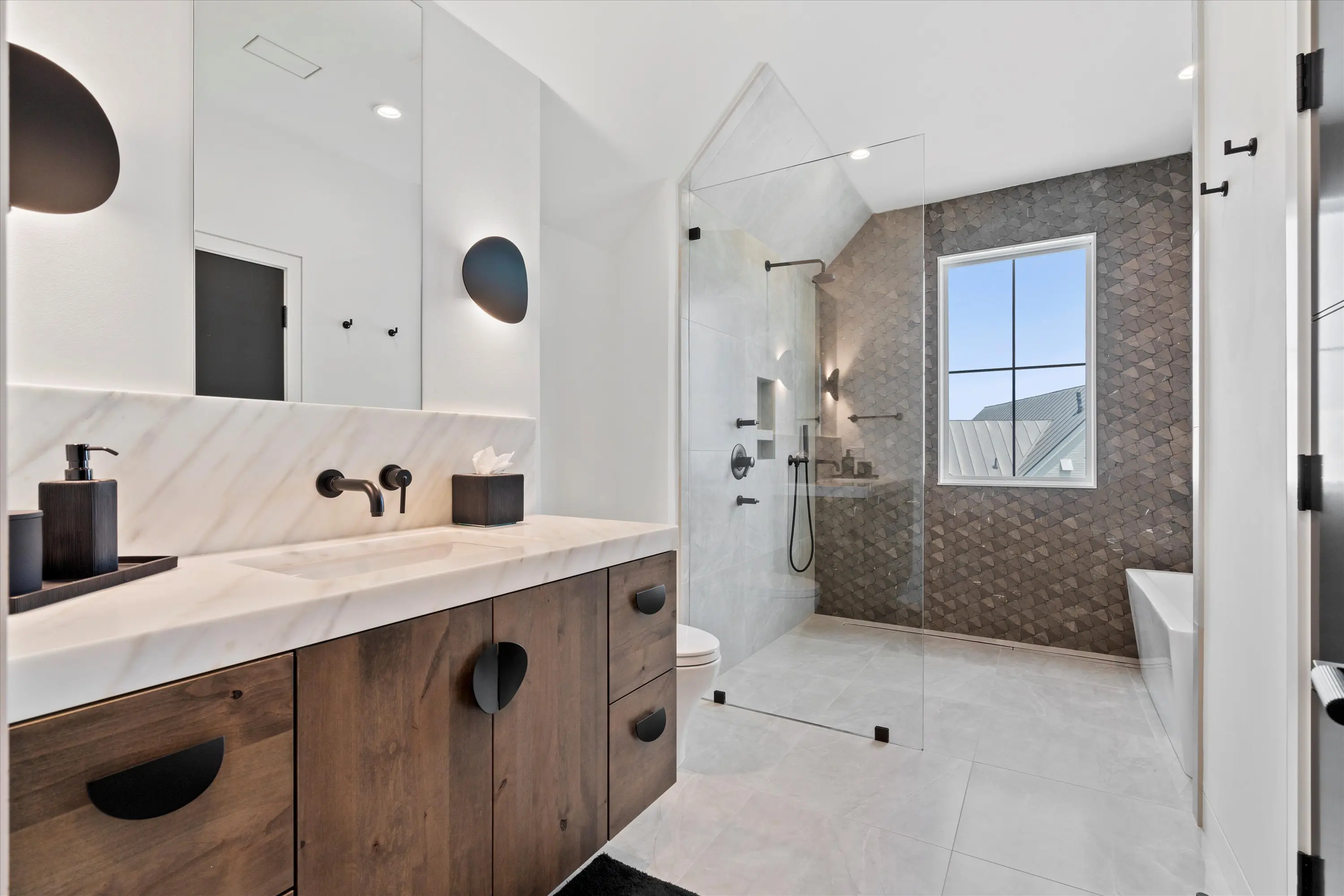 Modern bathroom with wooden vanity and glass shower enclosure.
