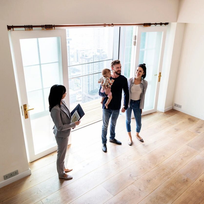 Family touring an empty apartment with realtor.